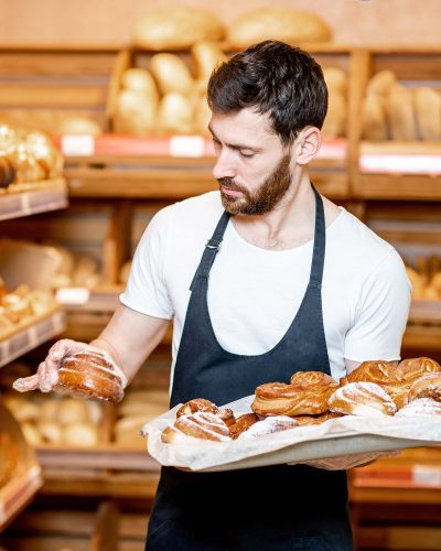 baker-with-fresh-pastries-in-the-supermarket-P8EHCL3.jpg